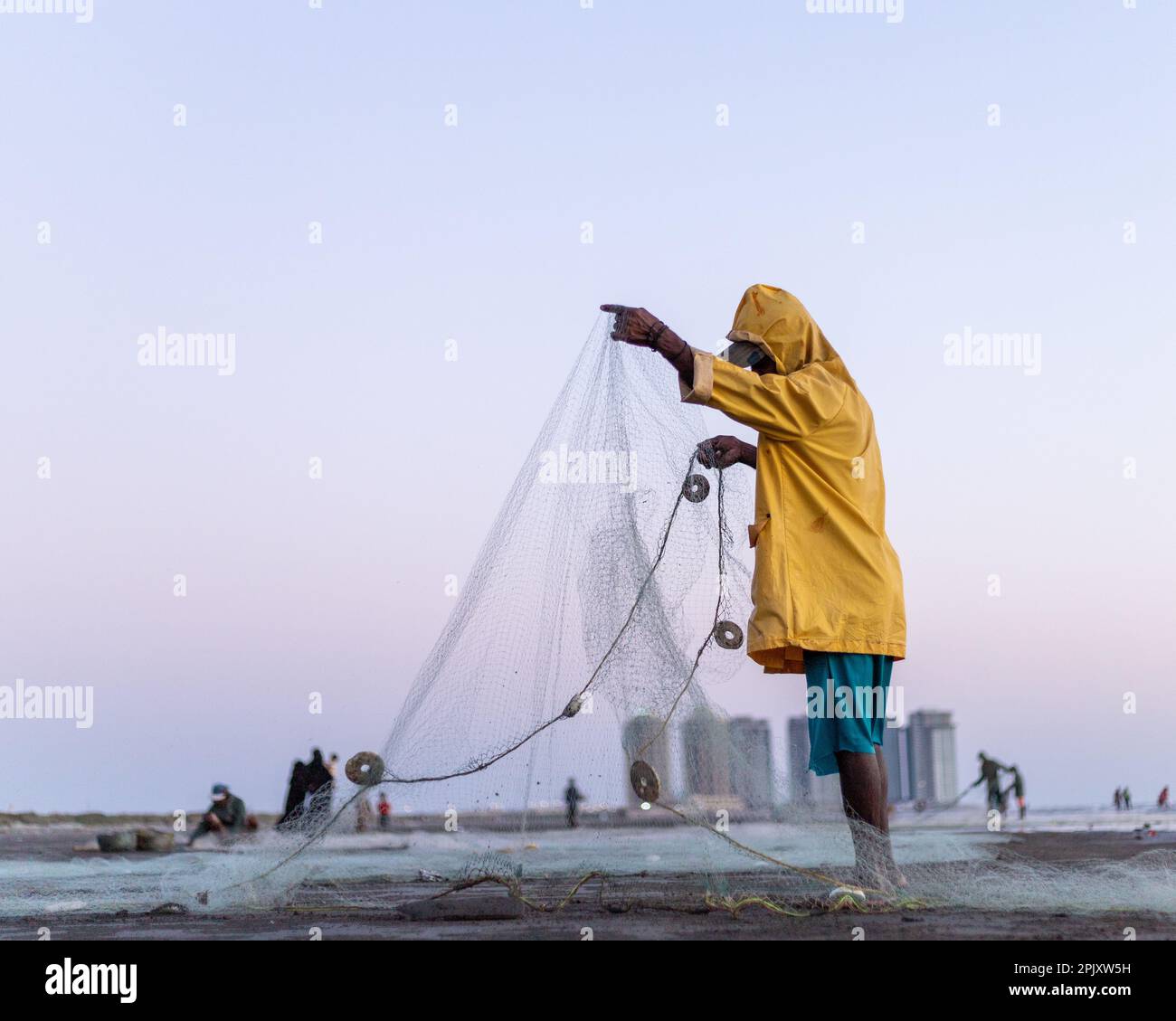 karachi pakistan 2021, a fisherman wearing yellow jacket preparing