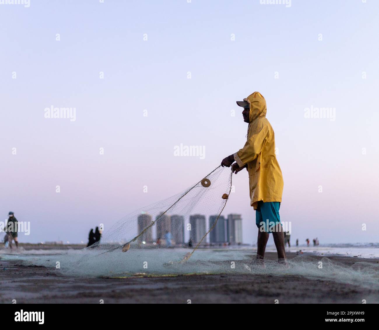 karachi pakistan 2021, a fisherman wearing yellow jacket preparing
