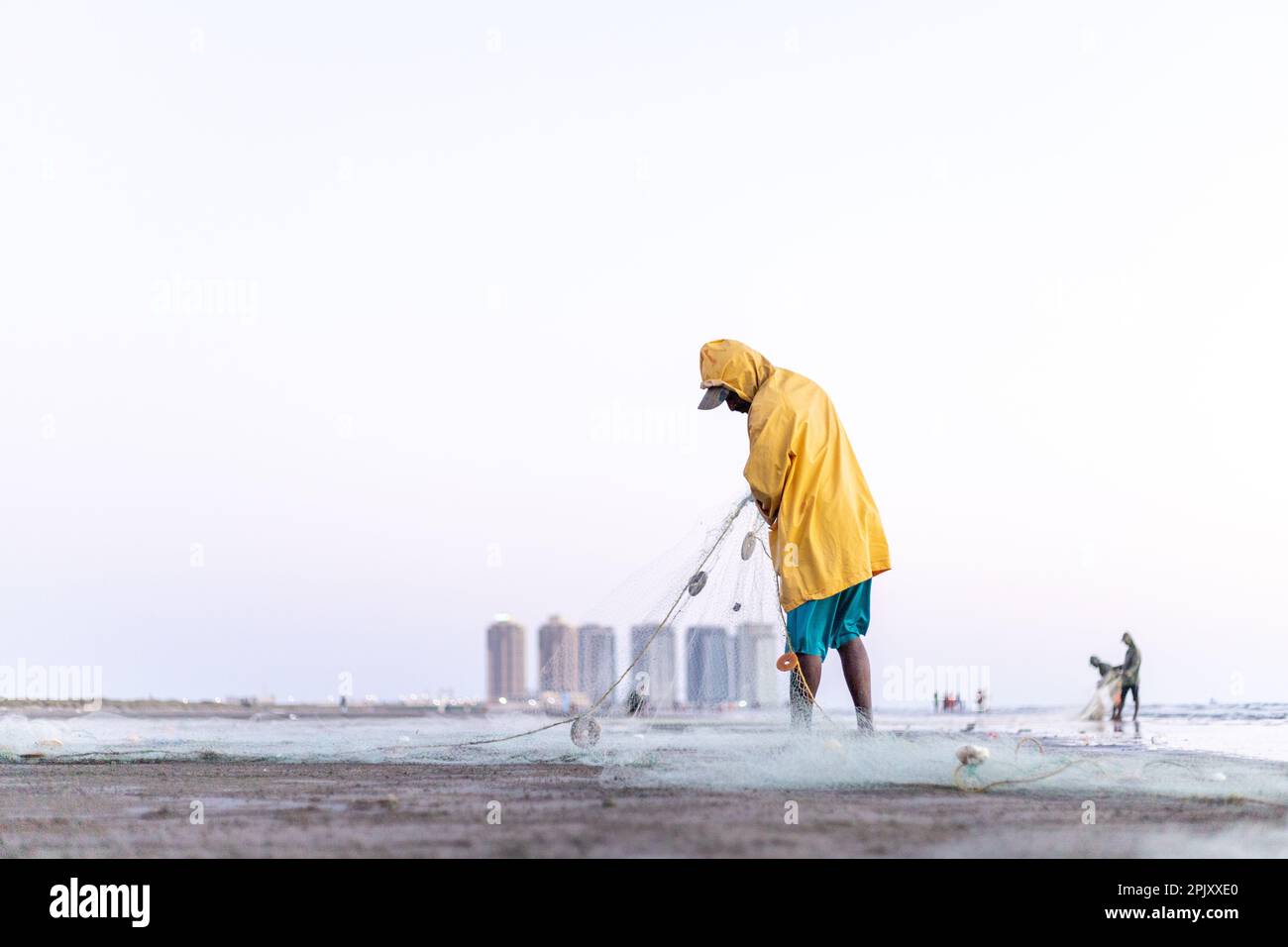 karachi pakistan 2021, a fisherman wearing yellow jacket preparing