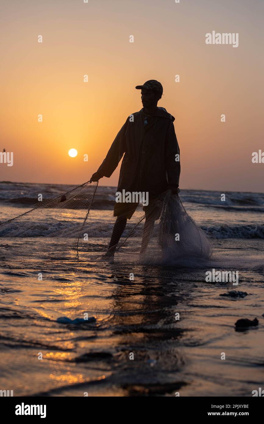 karachi pakistan 2021, a fisherman pulling fishing net to catch fish