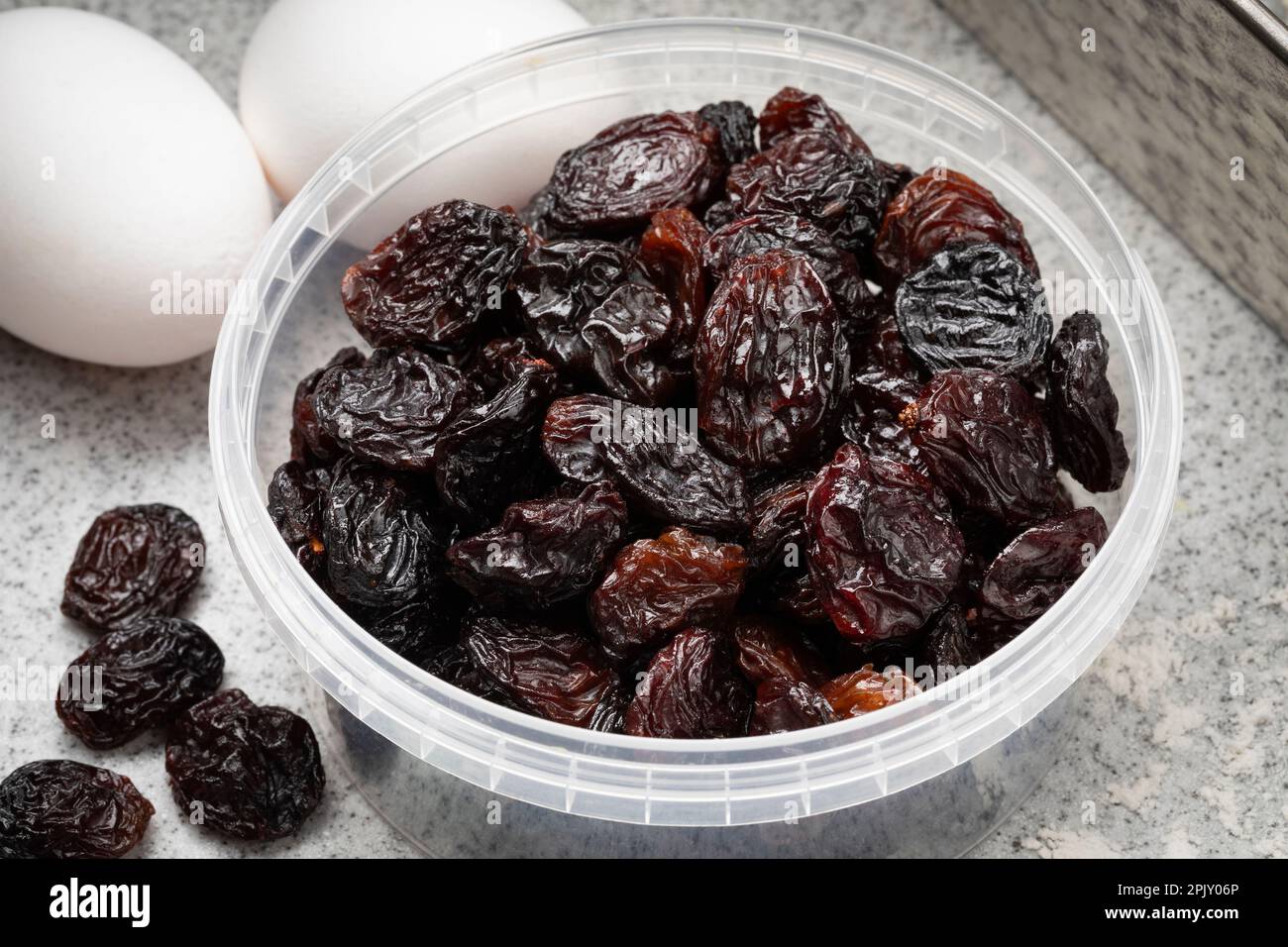 Plastic bowl with black flame raisins from Chili close up for baking Stock Photo