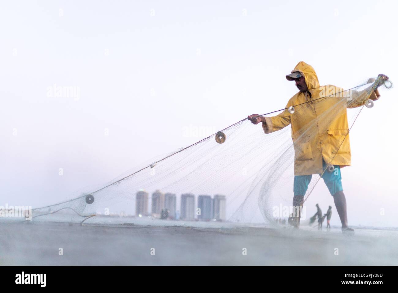karachi pakistan 2021, a fisherman wearing yellow jacket preparing