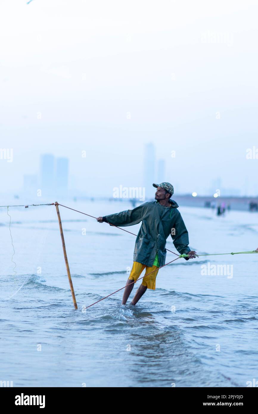karachi pakistan 2021, a fisherman pulling fishing net to catch fish