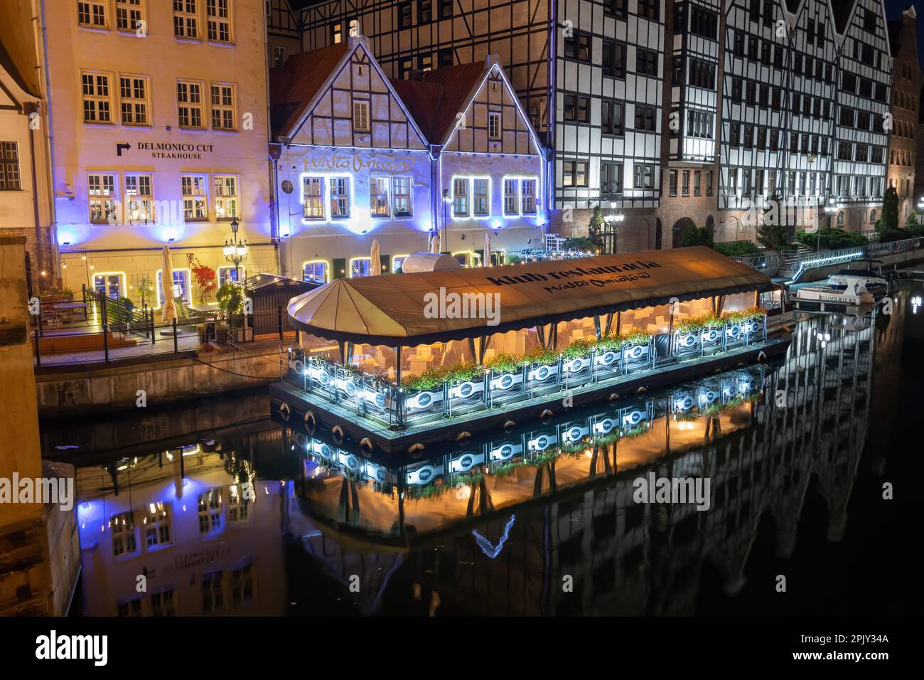 City of Gdańsk, Poland - October 9, 2022 - Granary Island beautiful riverfront at night with Club restaurant City of Angels (Polish: Miasto Aniołów) a Stock Photo