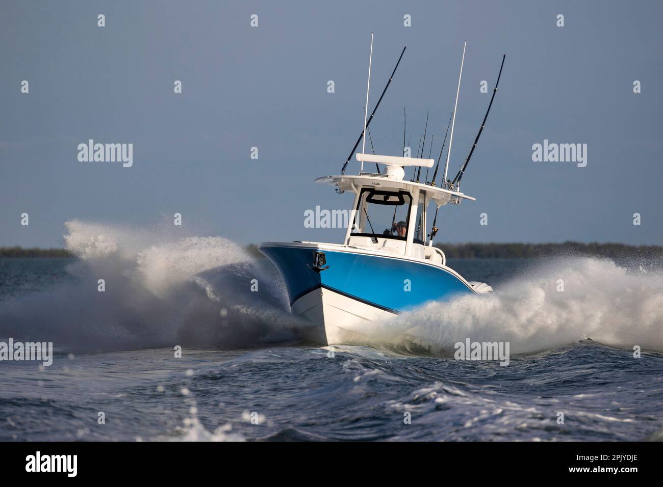 An approaching center console fishing boat throwing big spray in the