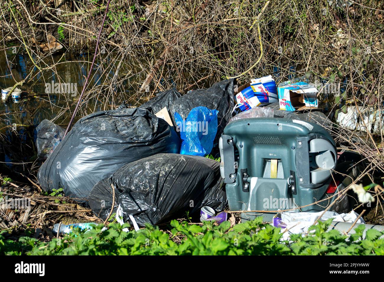 Denham, Buckinghamshire, UK. 4th April, 2023. Shocking amounts of fly-tipping and litter in a stream in Denham, Buckinghamshire including asbestos sheeting, tyres, a fridge freezer, engine oil containers and plastic. The Government has announced tougher measures for those convicted of anti social behaviour including illegal fly-tipping. Credit: Maureen McLean/Alamy Live News Stock Photo