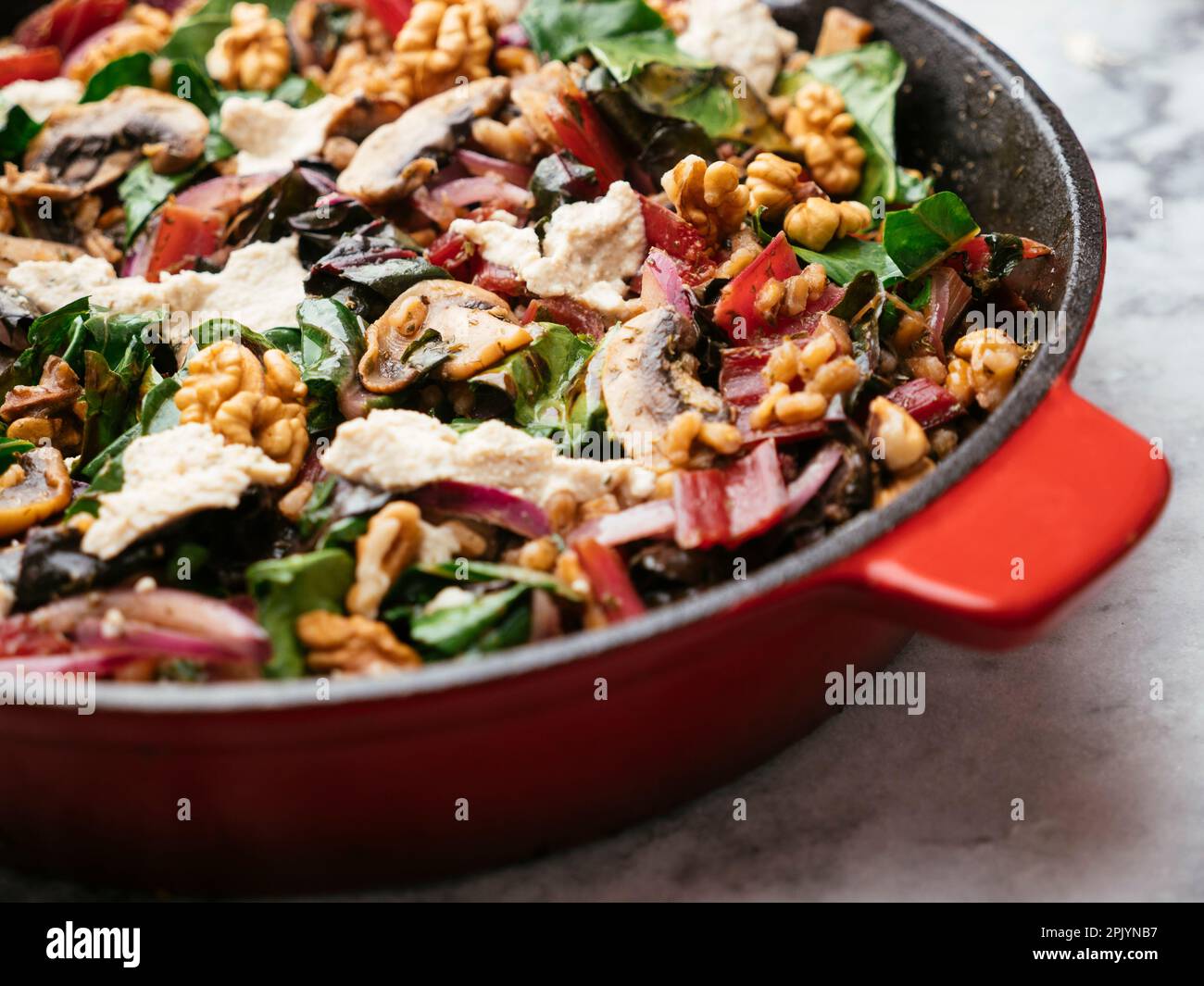 Spelt with red swiss chard, mushrooms, walnuts and vegan feta in a cast