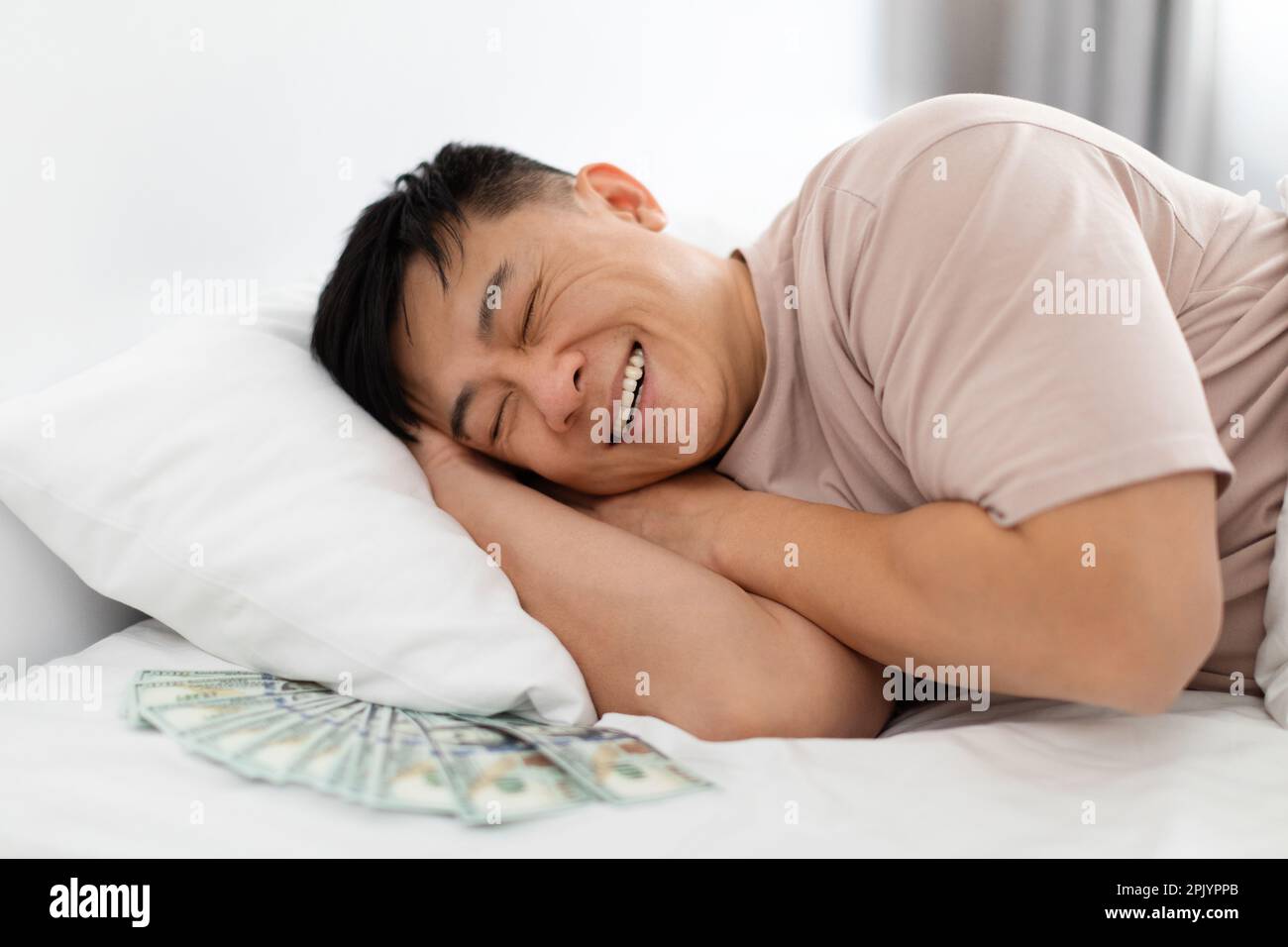 Chinese guy enjoying his sleep while keeping money under pillow Stock