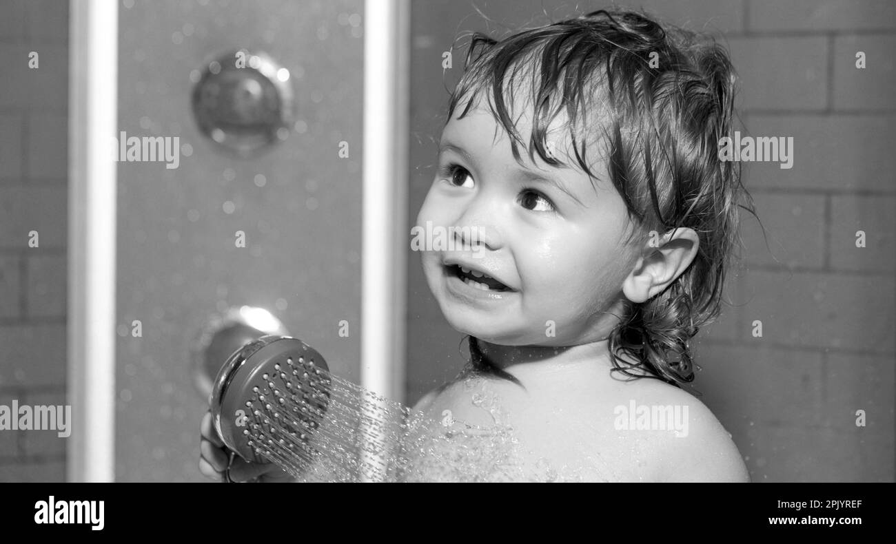 Funny happy baby bathes in bathtub with water and foam. Child bathing