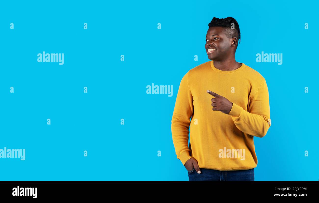 Handsome Black Man Pointing Aside At Copy Space With Hand Stock Photo