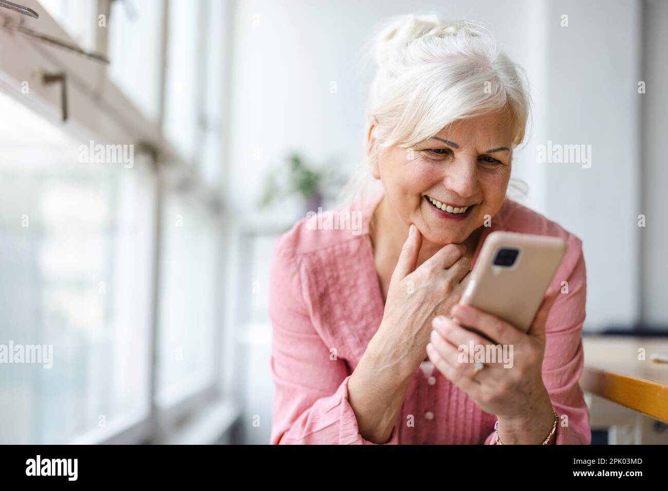Smiling senior woman using smartphone Stock Photo