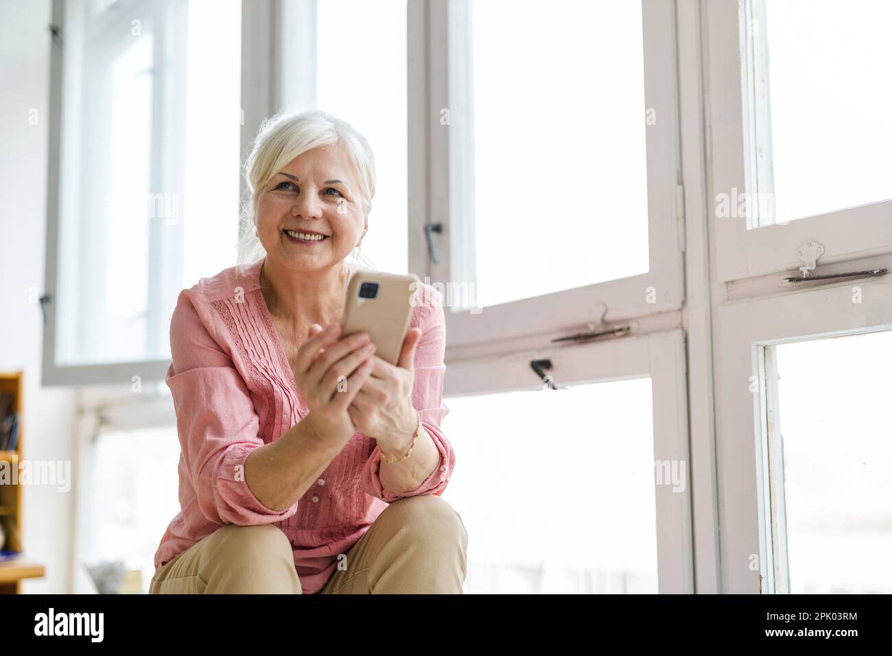 Smiling senior woman using smartphone Stock Photo