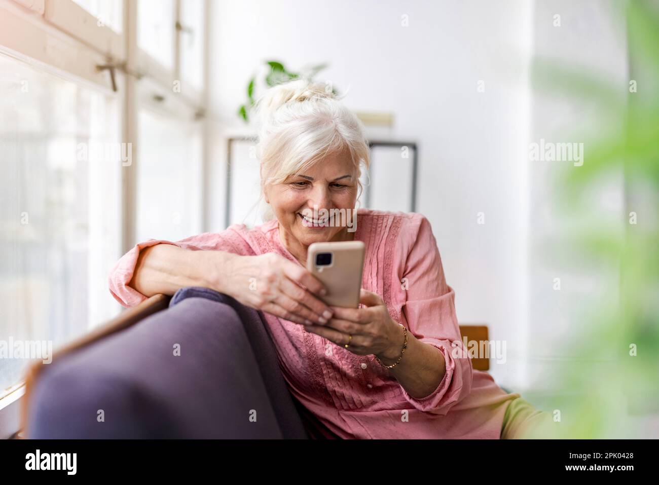 Smiling senior woman using smartphone Stock Photo