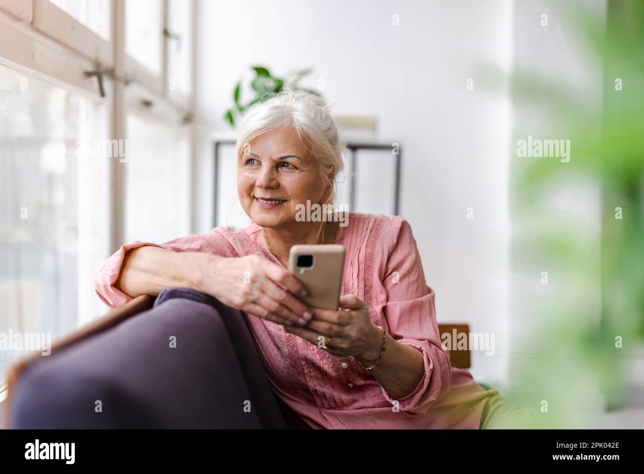 Smiling senior woman using smartphone Stock Photo
