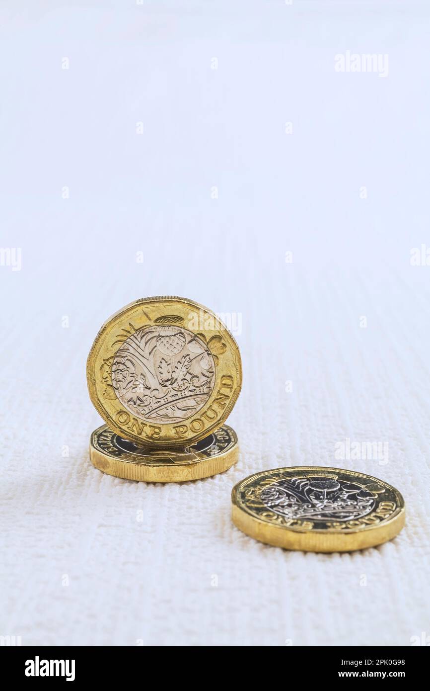 UK One pound coins on white textured background. Stock Photo