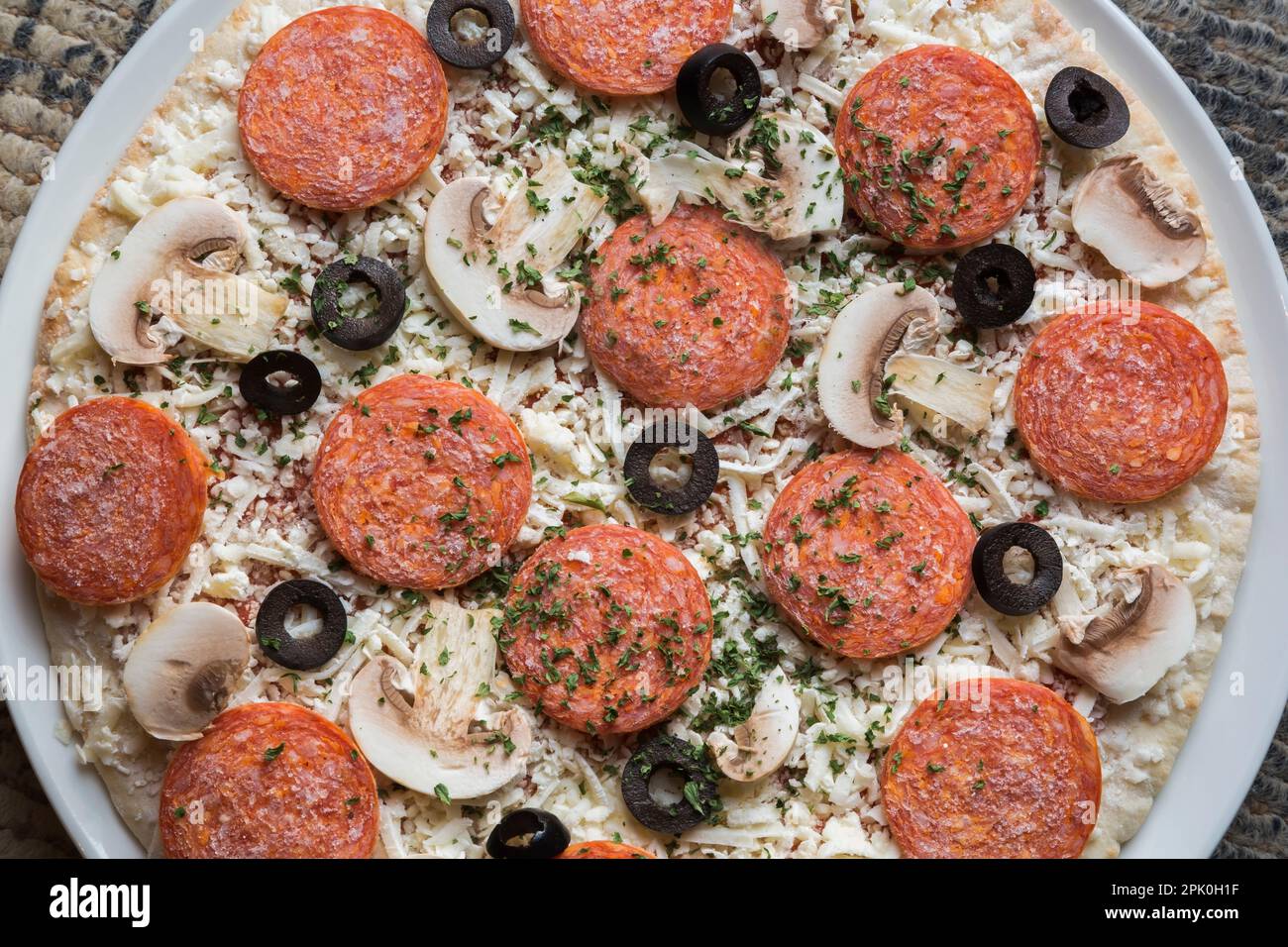 Frozen pepperoni and cheese pizza with black olives and white mushrooms