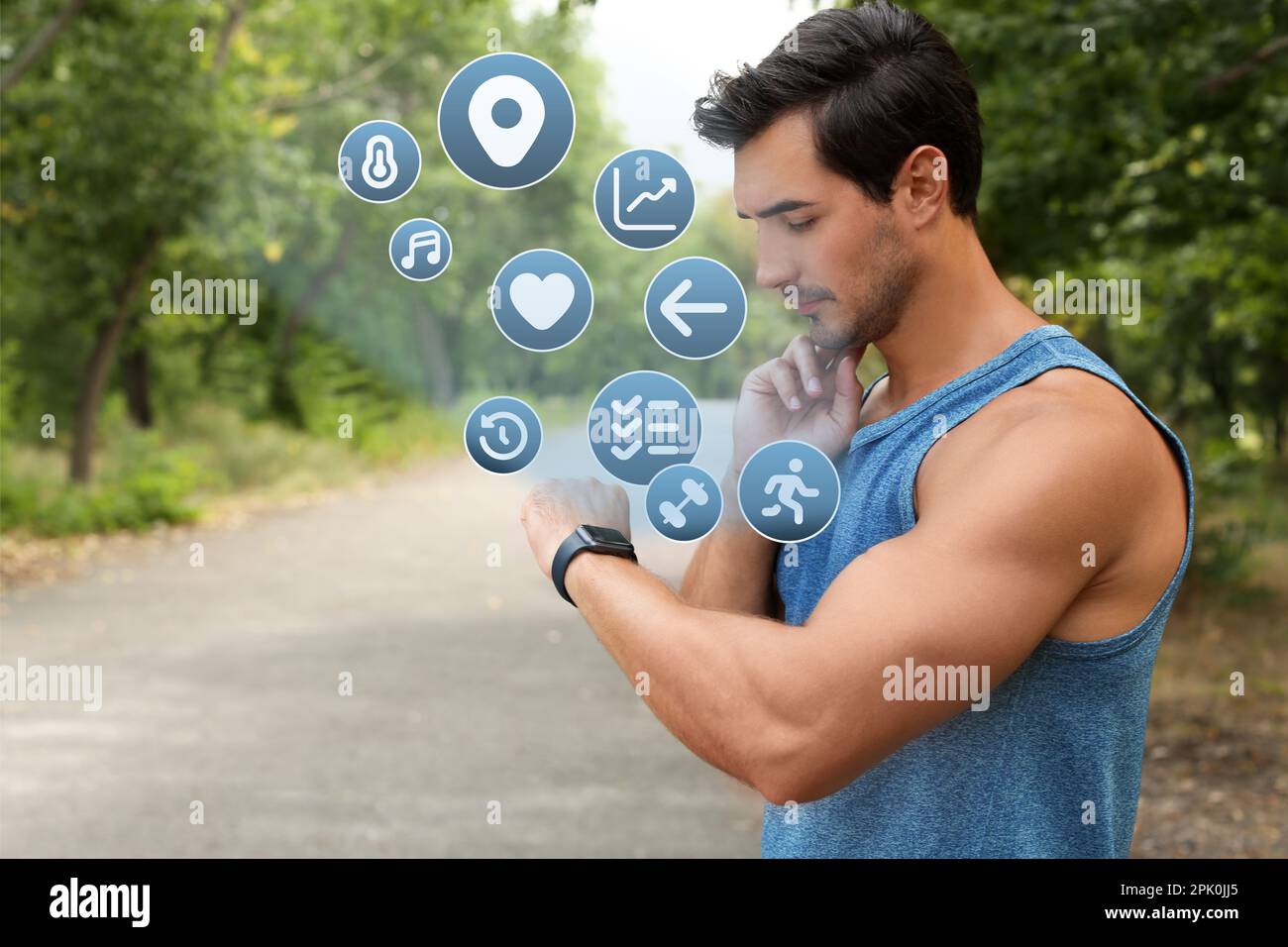 Young man checking fitness tracker after training in park Stock Photo