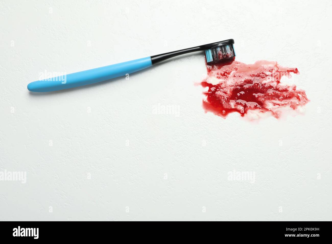 Toothbrush with blood on white table, top view and space for text. Gum