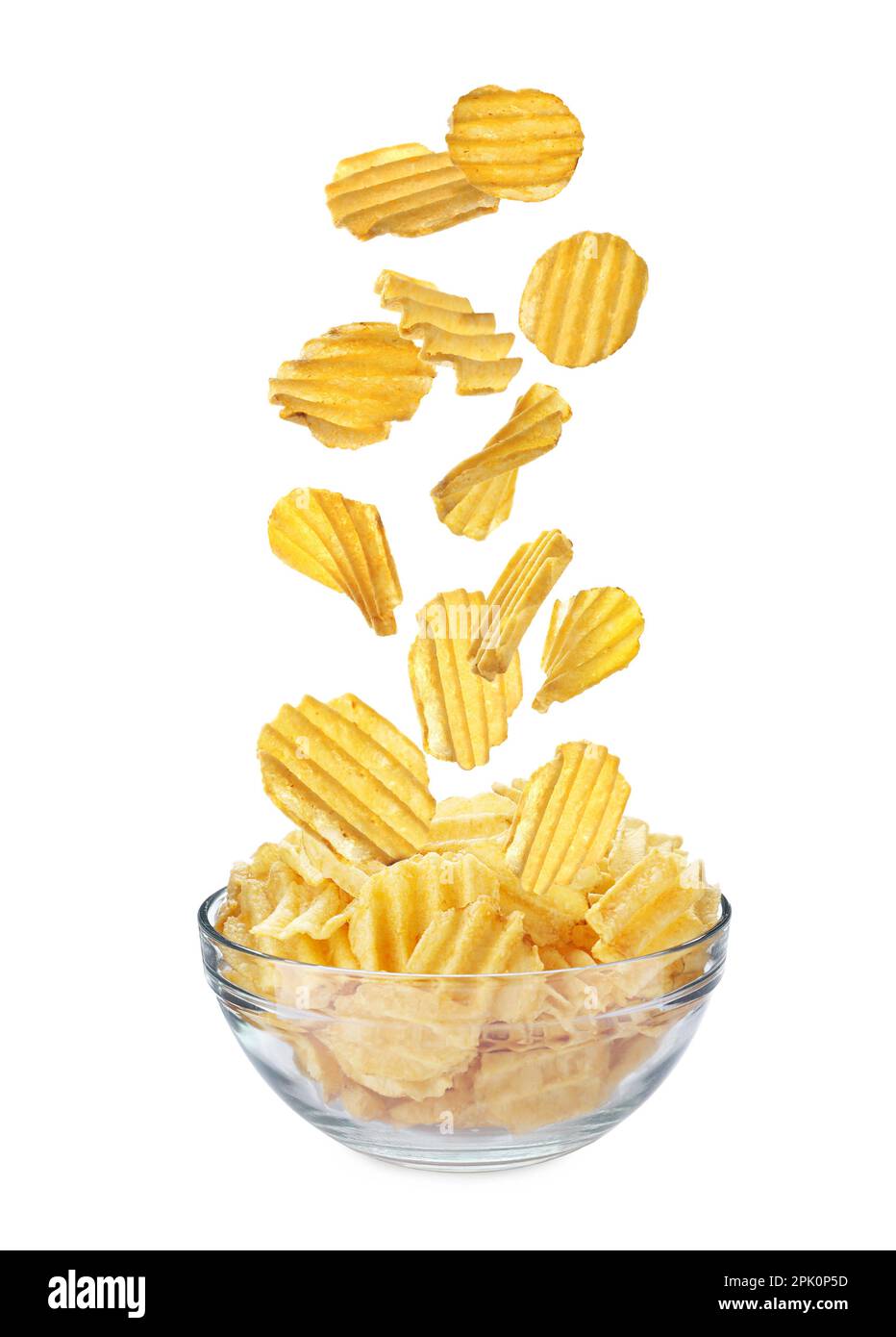 Ridged crispy potato chips falling into bowl on white background Stock Photo
