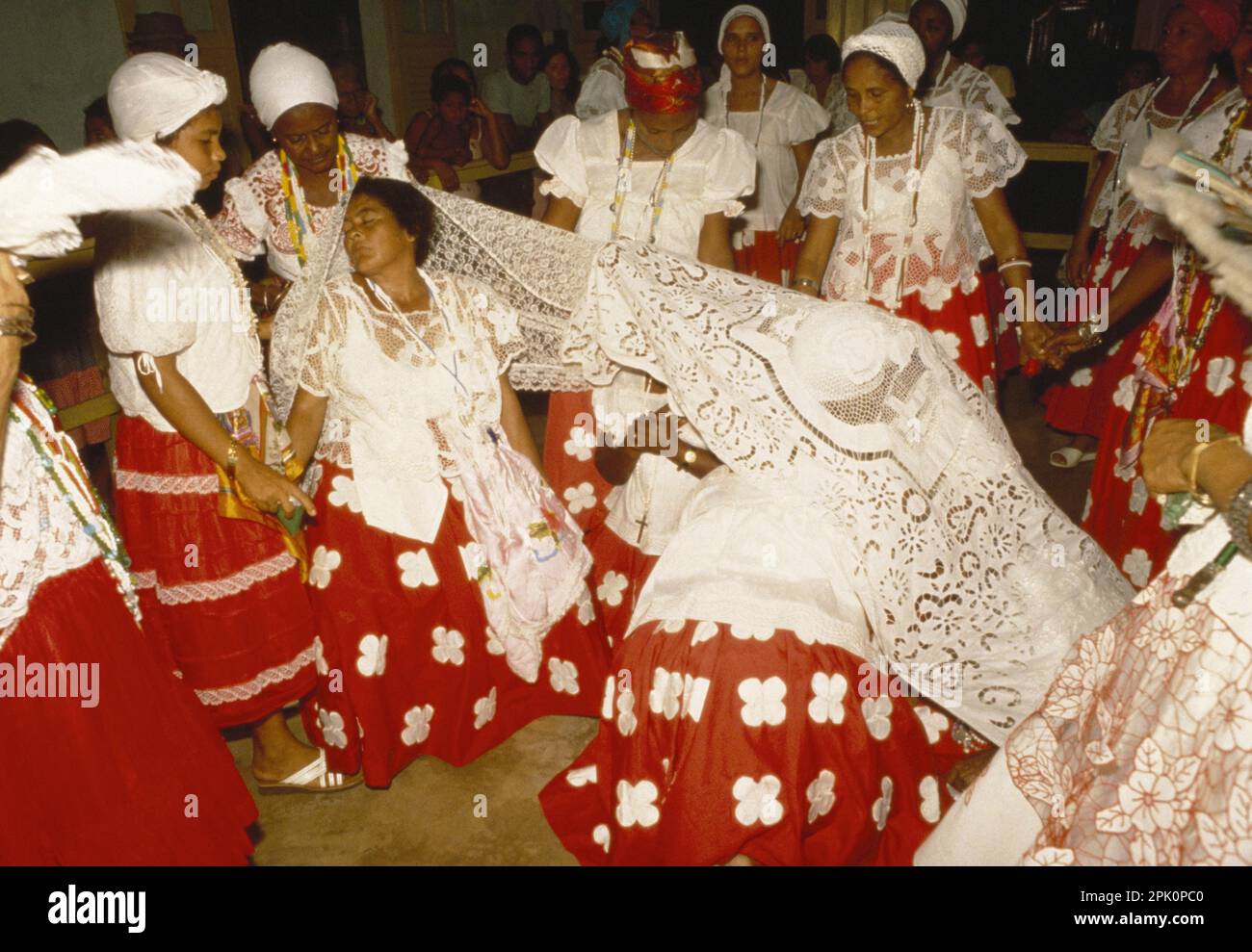 Tambor de Mina, syncretic Afro-Brazilian spirit possession religion. Two cult members (filhas de santo) in trance are covered with a ritual cloth Stock Photo