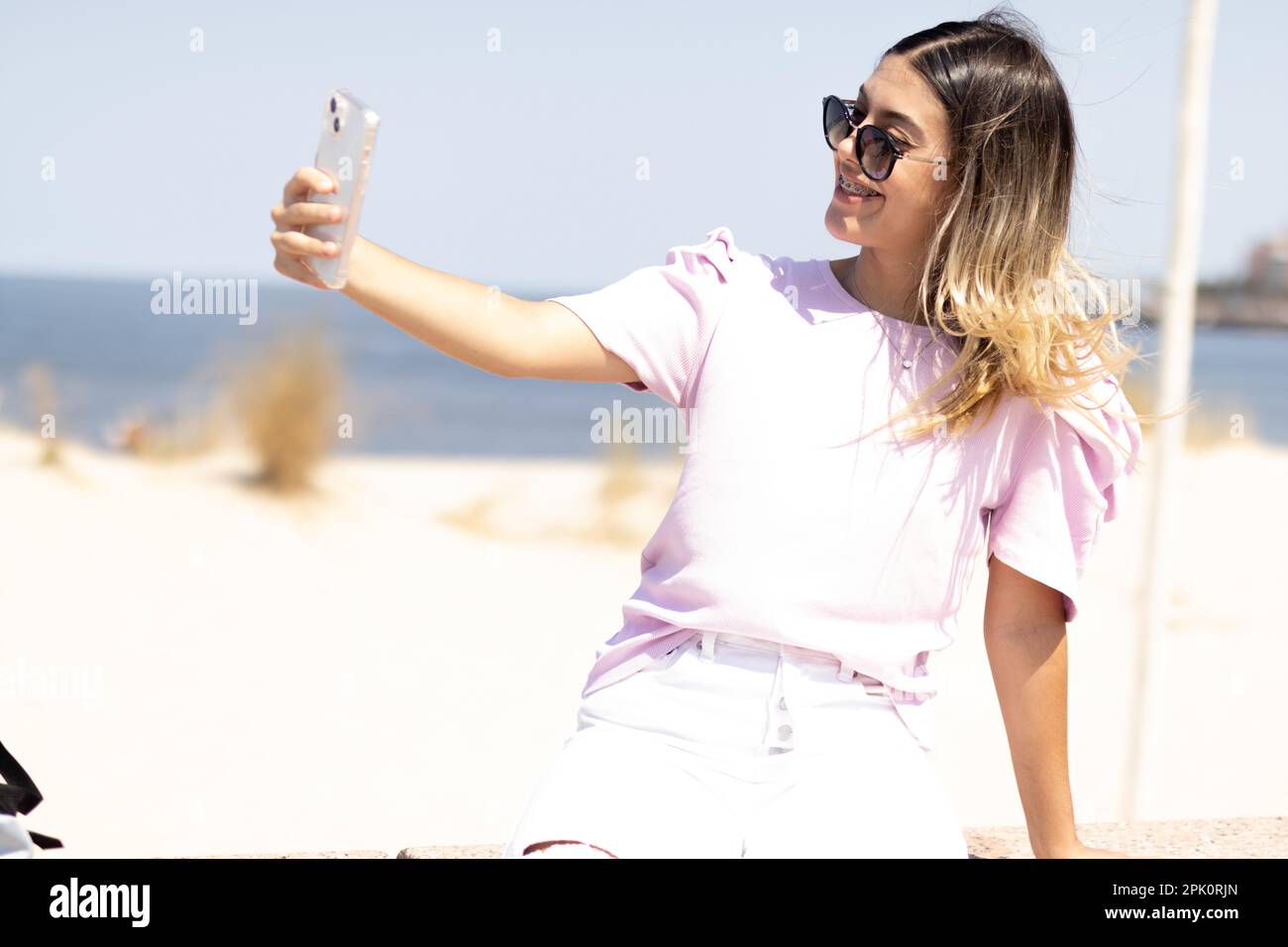 Teenager girl laughing taking a selfie with her smartphone on the ...