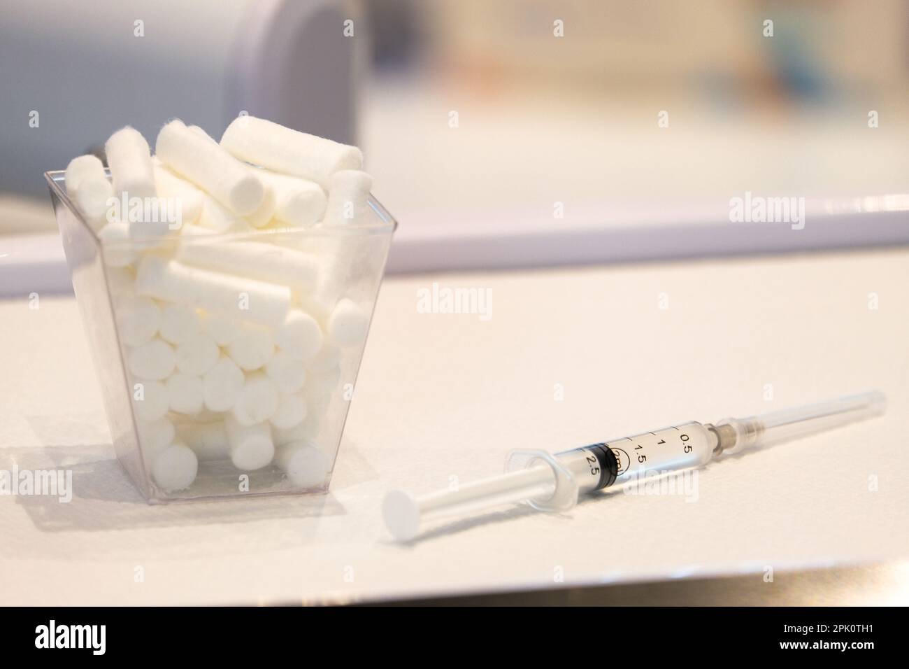 Close up needle syringe and mouth cotton on dentist work ground