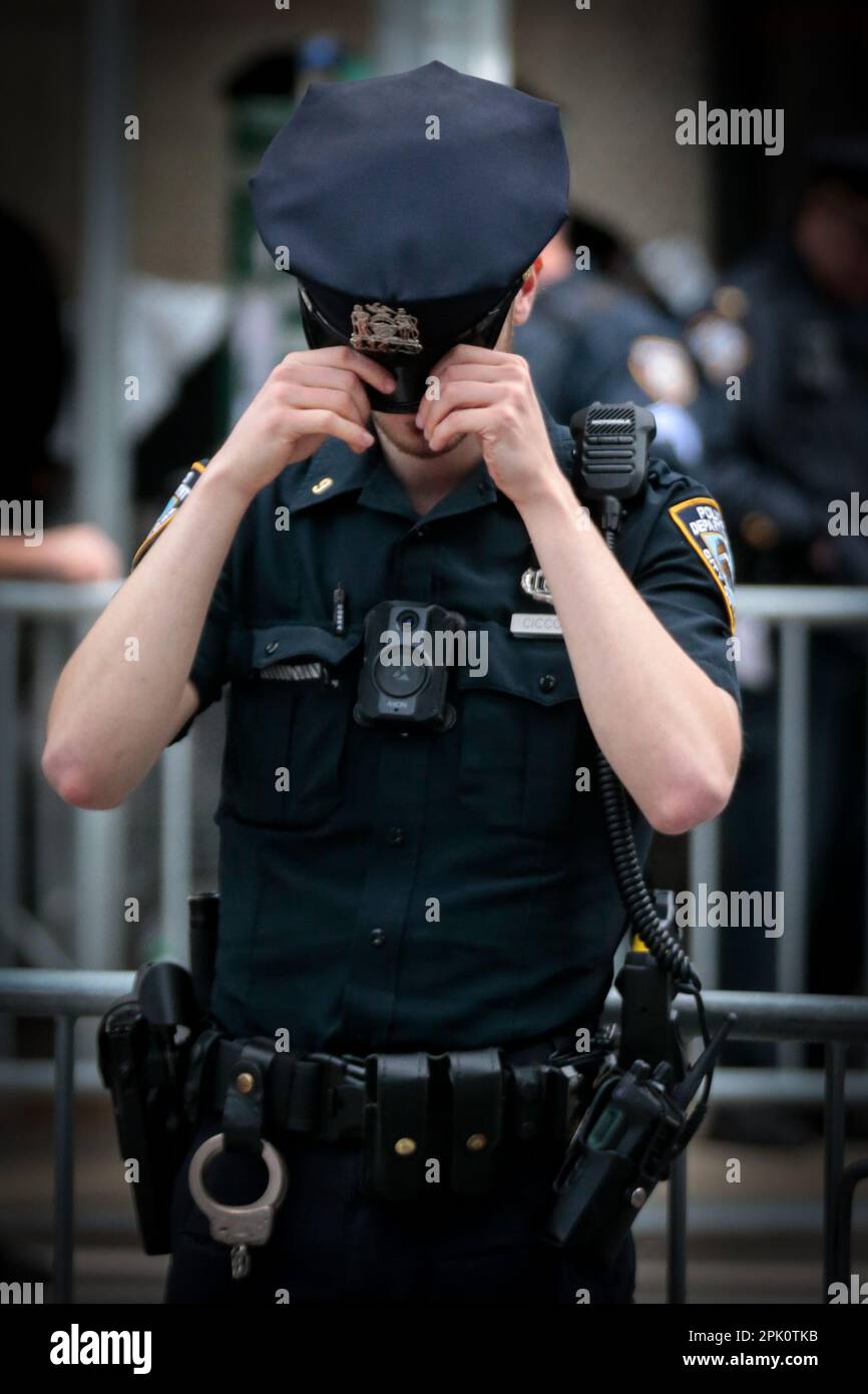 New York, New York, USA. 4th Apr, 2023. A police officer adjust his hat outside of the Manhattan District Court in New York, ahead of the arrival of former American president Trump on the day of Trump's arraignment hearing. Trump's arraignment drew crowds and chaos. (Credit Image: © William Volcov/ZUMA Press Wire) EDITORIAL USAGE ONLY! Not for Commercial USAGE! Stock Photo