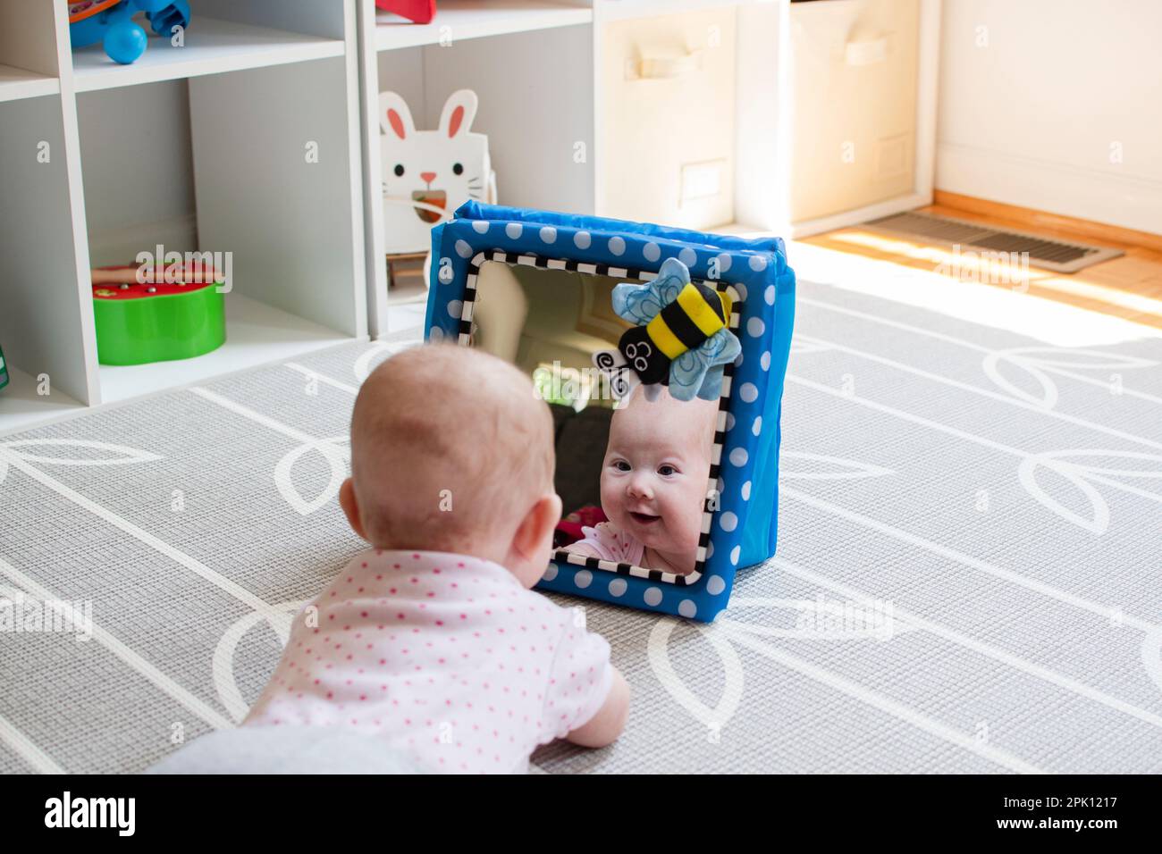 Baby looking in the mirror during tummy time Stock Photo Alamy