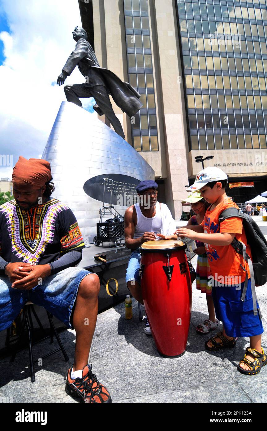 Street musicians playing by the Monument to Adam Clayton Powell in