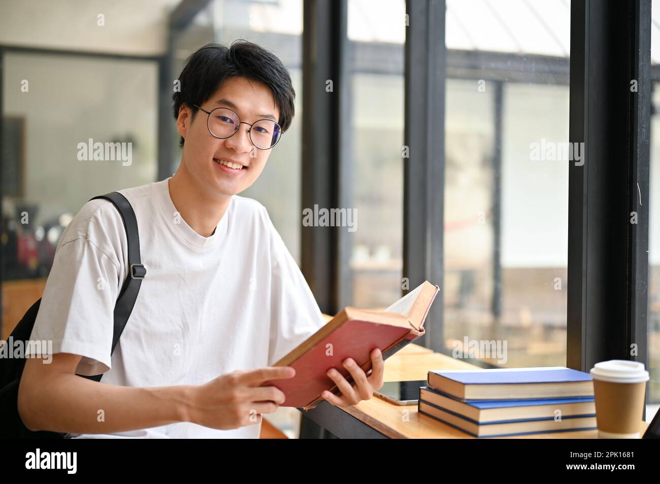 Smart and handsome young Asian male college student wearing eyeglasses ...