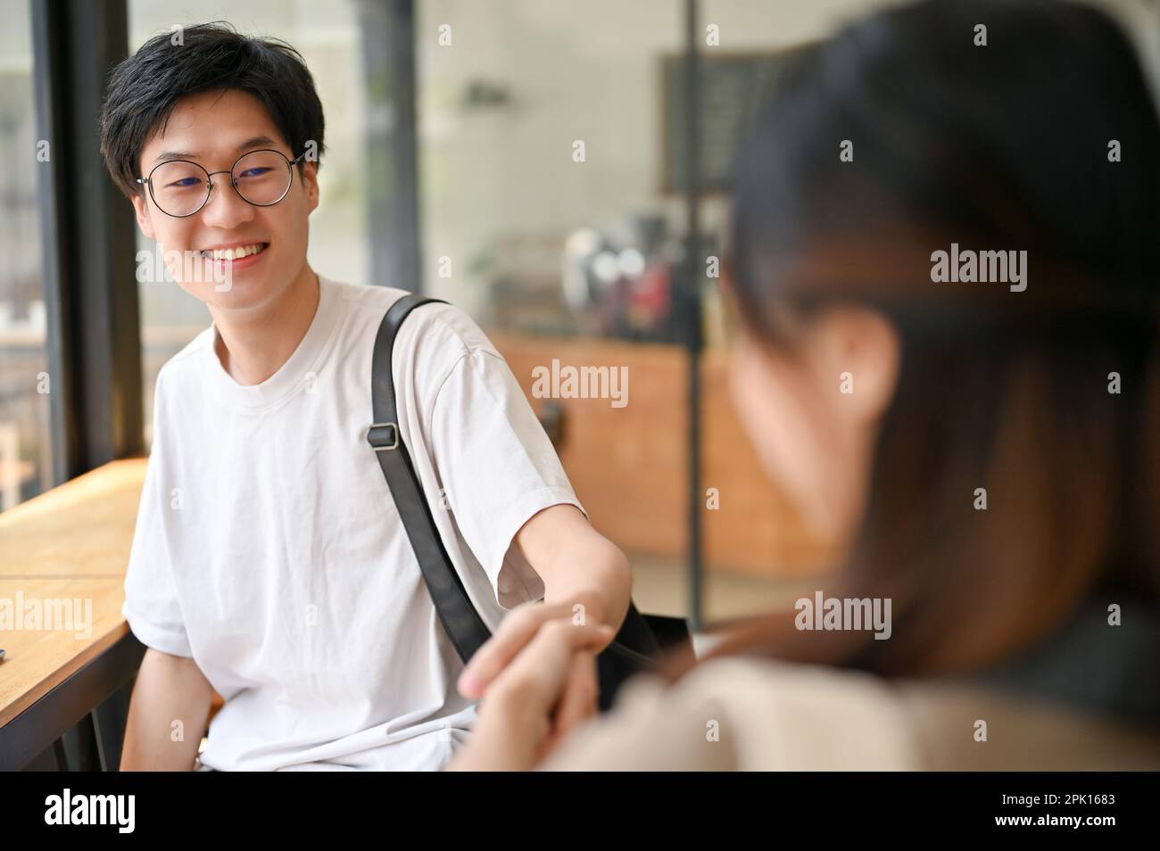 Handsome and happy young Asian male college student shaking hand with a ...