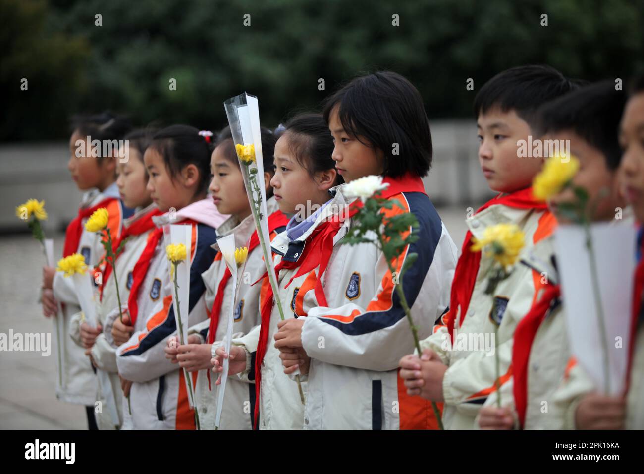 NANJING, CHINA - APRIL 5, 2023 - Students present flowers to revolutionary martyrs at Yuhuatai Martyrs Cemetery in Nanjing, East China's Jiangsu Provi Stock Photo
