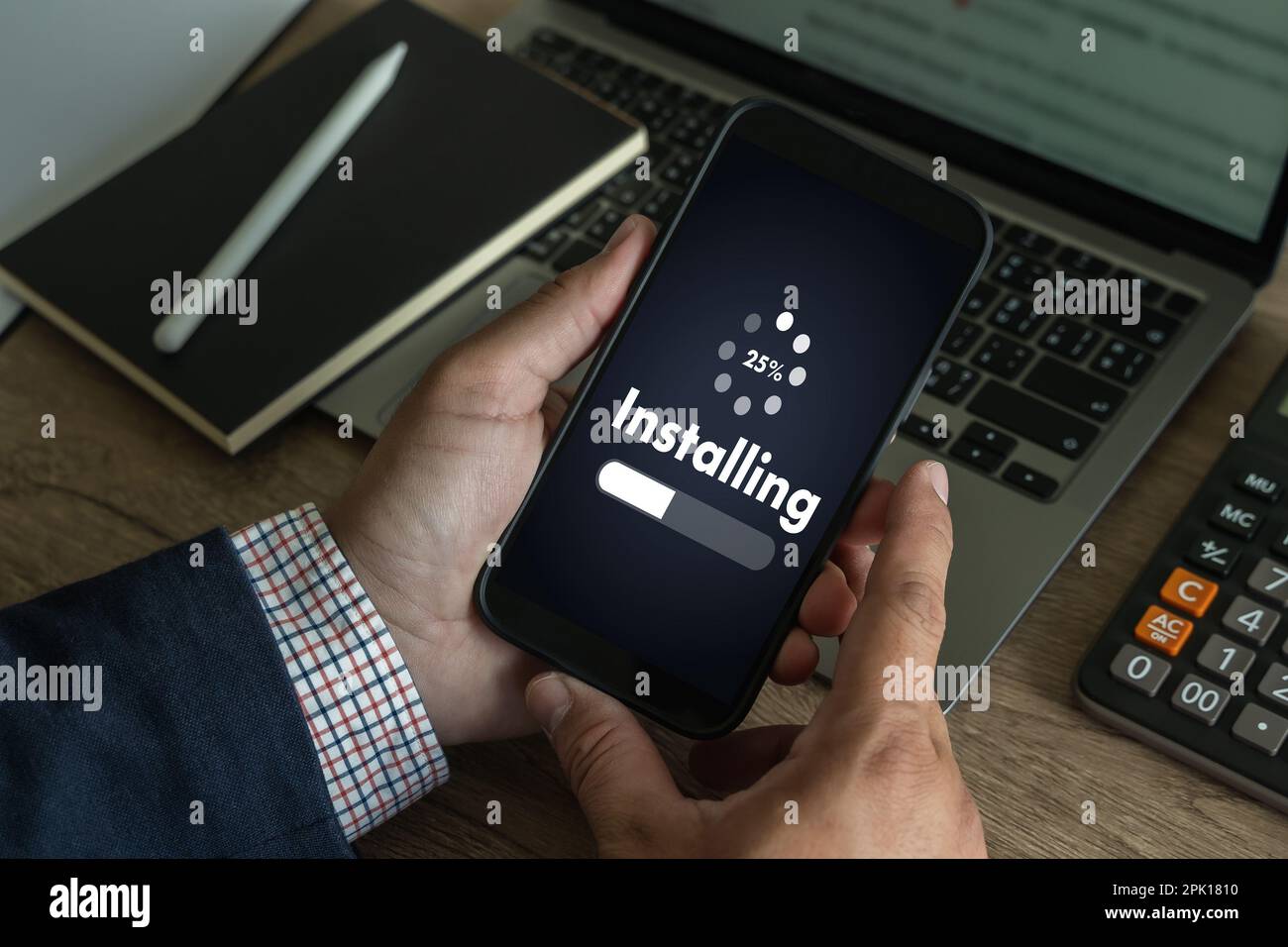 man installing Software Update On Mobile Phone And Laptop digital technology communication Stock Photo