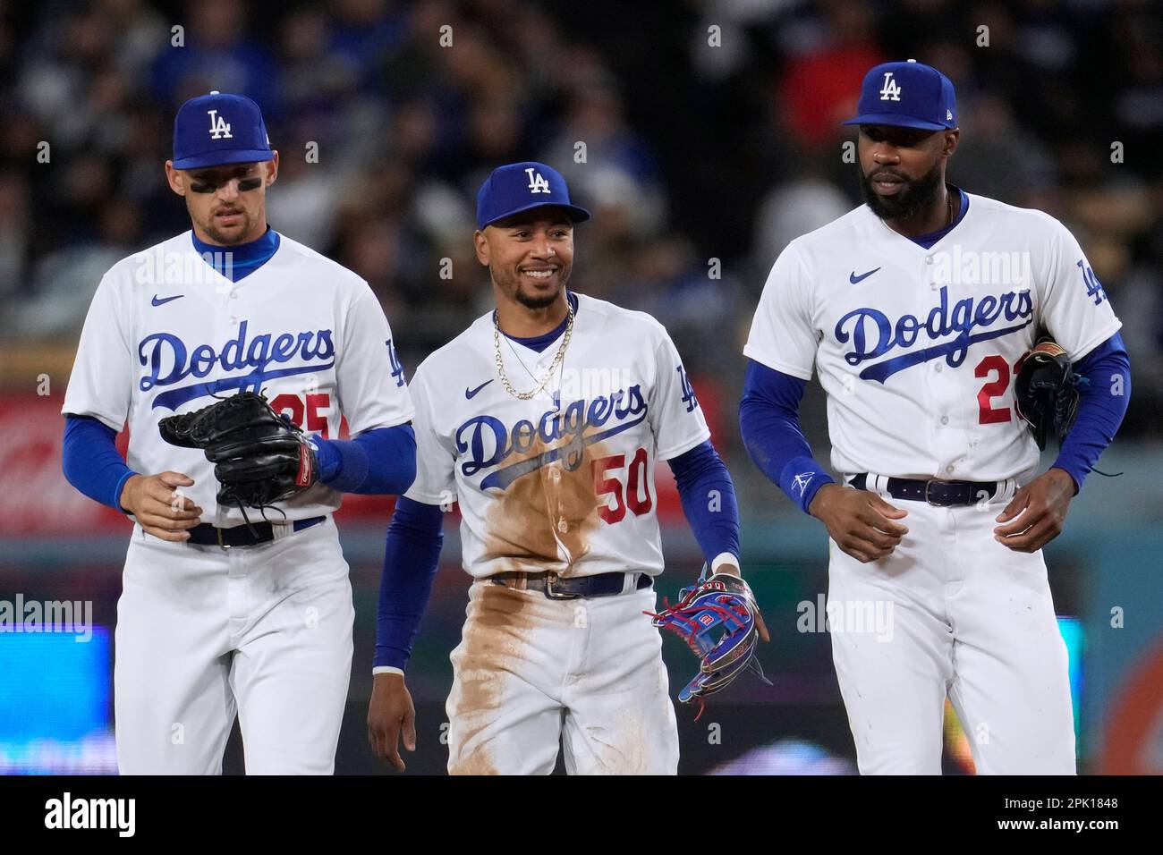 Los Angeles Dodgers second baseman Mookie Betts, center, walks back to the  dugout with right fielder Jason Heyward, right, and center fielder Trayce  Thompson after Betts made a catch and collided with