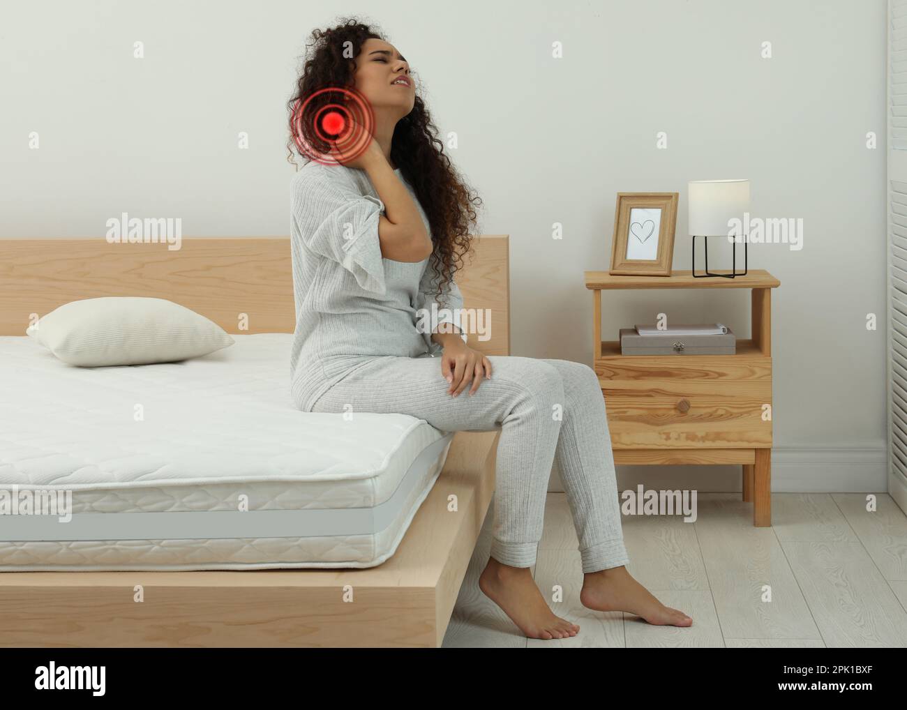 Woman suffering from neck pain after sleeping on mattress