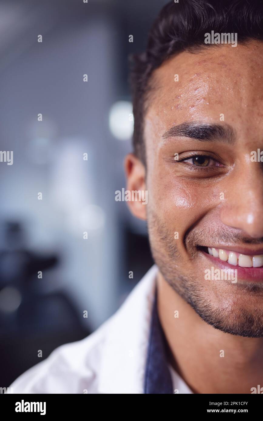 Half face portrait close up of happy biracial businessman smiling at office Stock Photo