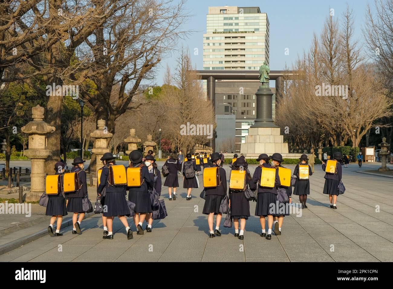 Tokyo, Japan - March 7, 2023: Girls in school uniform walking near the statue of Omura Masujiro in Chiyoda, Tokyo, Japan. Stock Photo