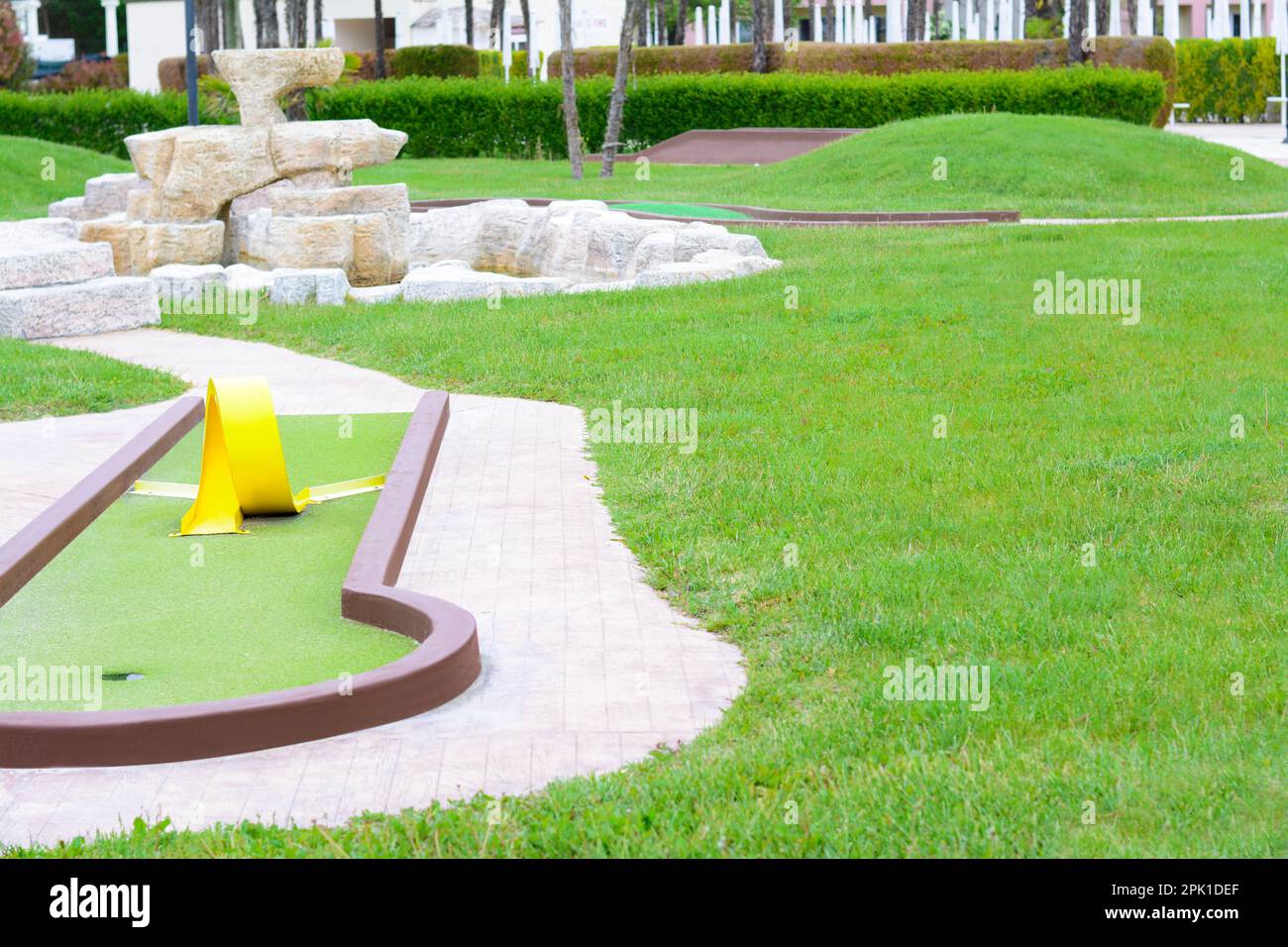Green lawn with fresh grass, mini golf course and fountain outdoors