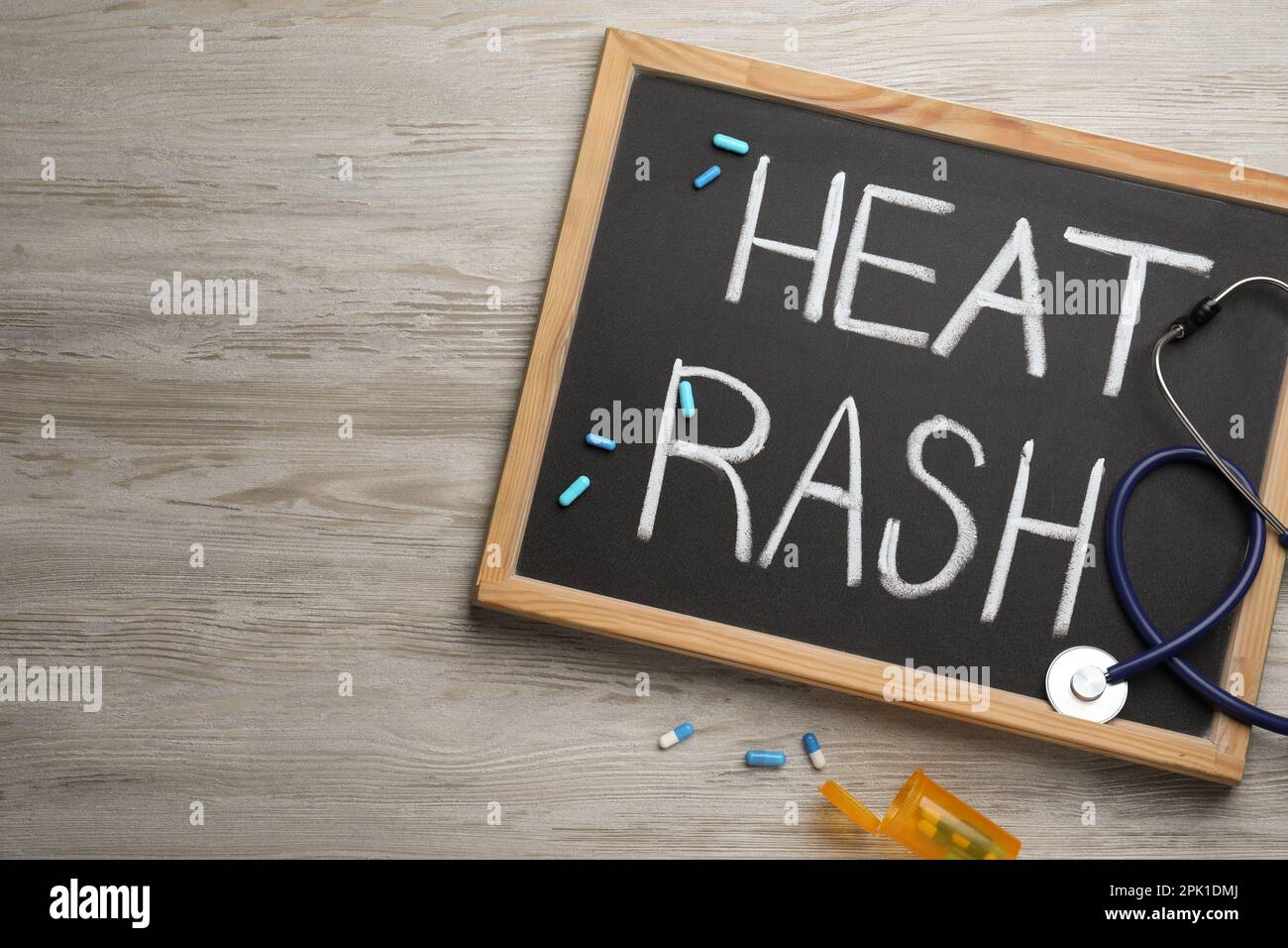 Blackboard with words Heat Rash, stethoscope and pills on wooden table ...
