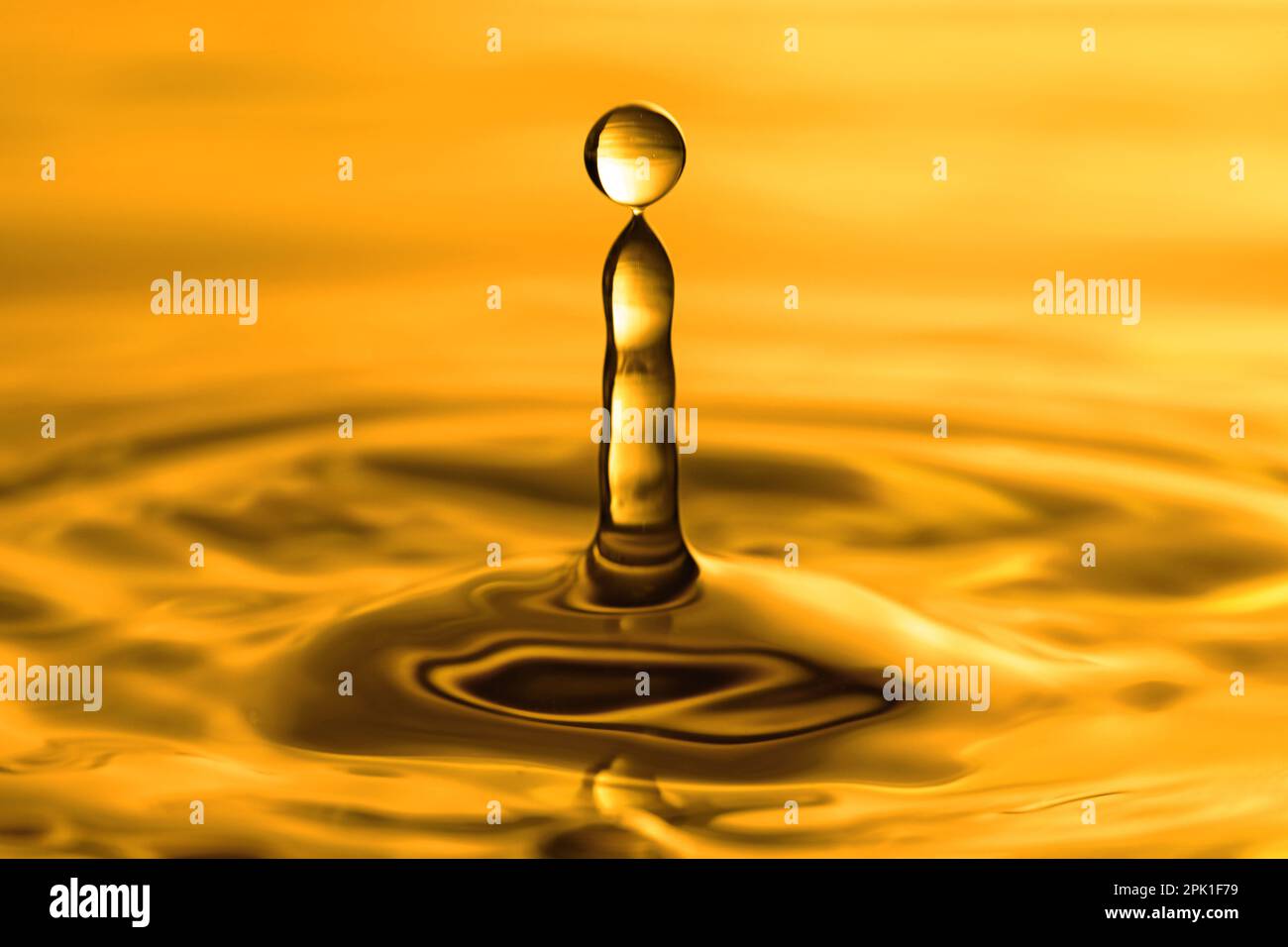 Splash of golden oily liquid with drop as background, closeup Stock ...