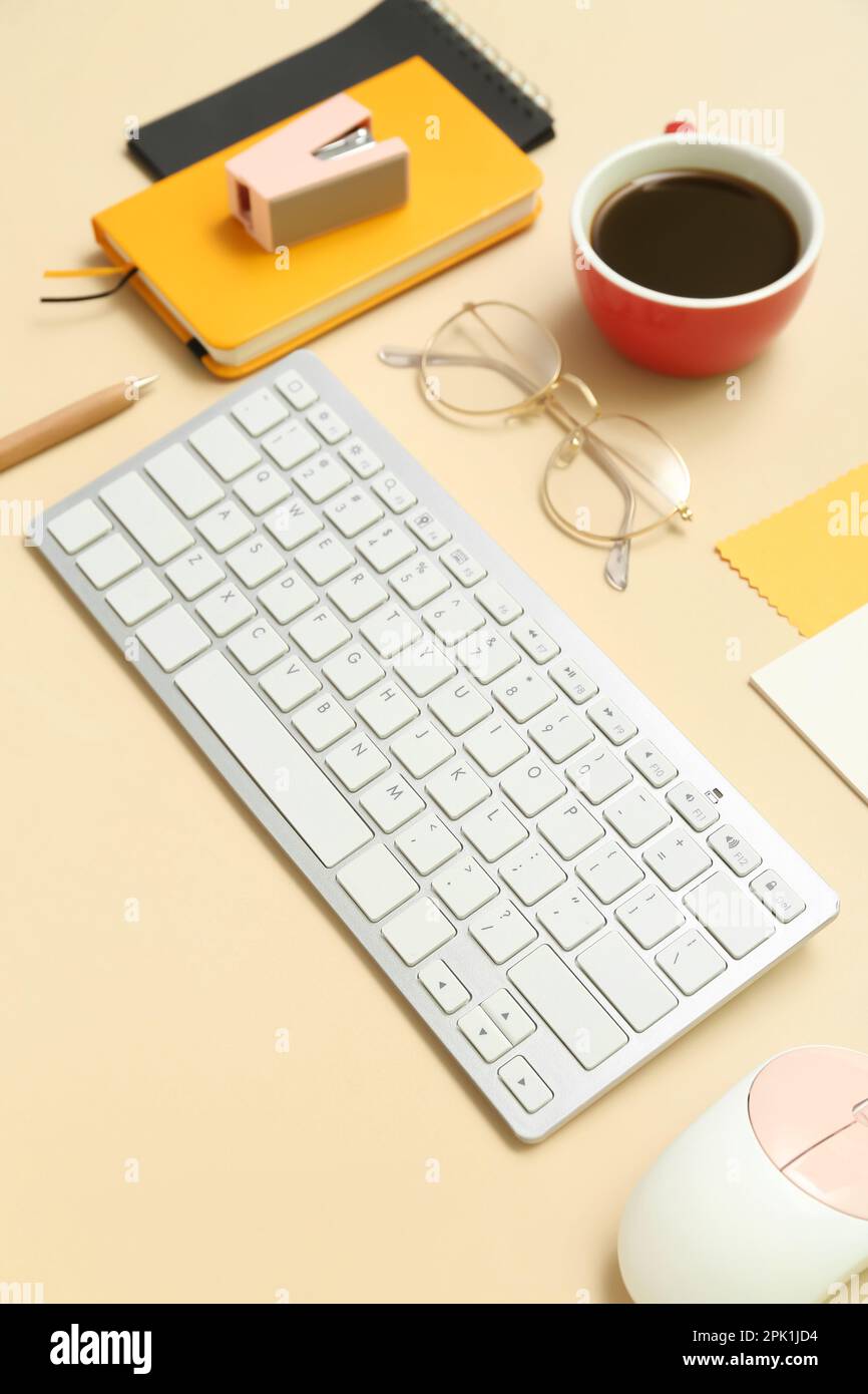Composition with keyboard, coffee, calculator and notepad on beige background Stock Photo