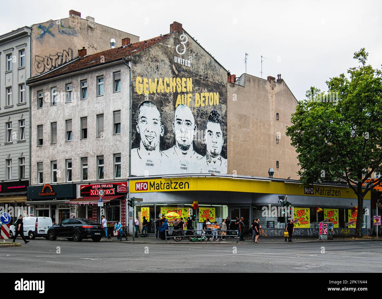 A mural of Boateng brothers, Jerome, George and Kevin-Prince, with a slogan reading 'Grown on concrete’, Gesundbrunnen, Mitte, Berlin Urban Art. Stock Photo