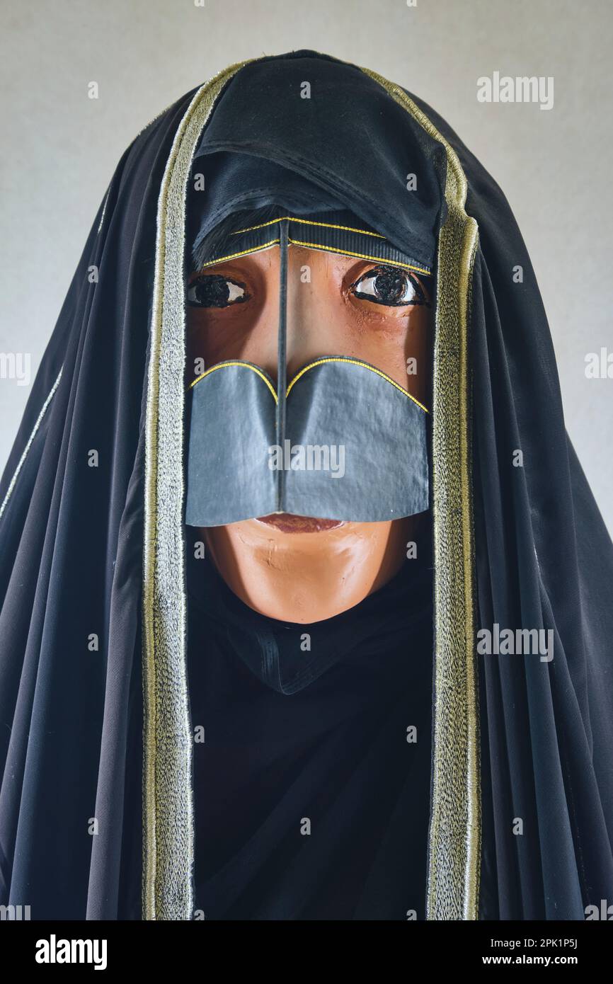 A woman mannequin, wearing typical traditional clothing, wardrobe and face covering. At the Emirates Heritage Club Heritage Village in Abu Dhabi, UAE, Stock Photo