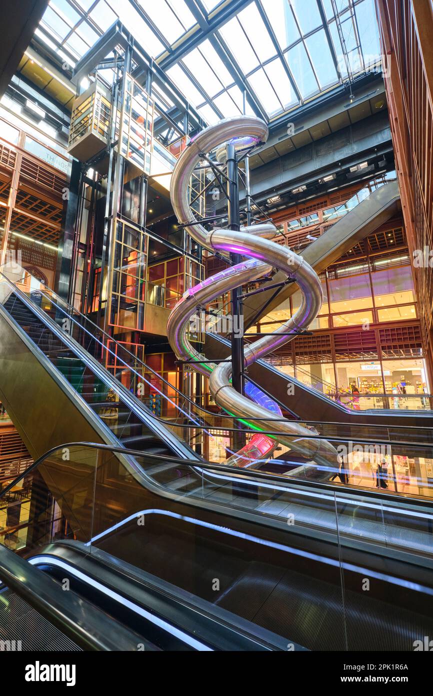 View of the twisting metal pipe ride, entertainment that fills a skylit atrium. At the Foster & Partners designed World Trade Center shopping mall in Stock Photo