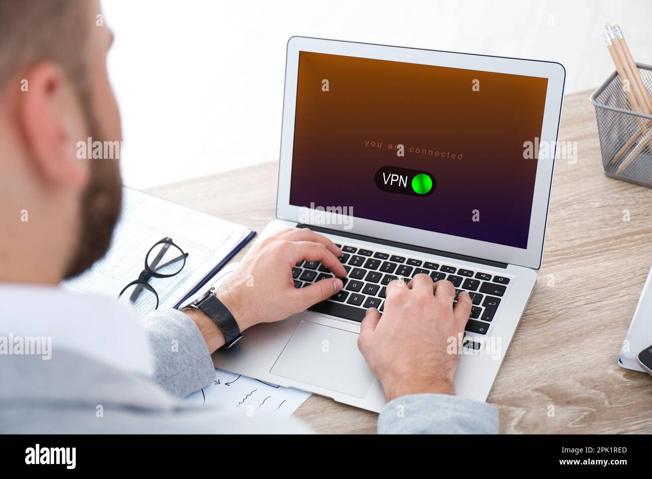 Man using laptop with switched on VPN at table, closeup Stock Photo