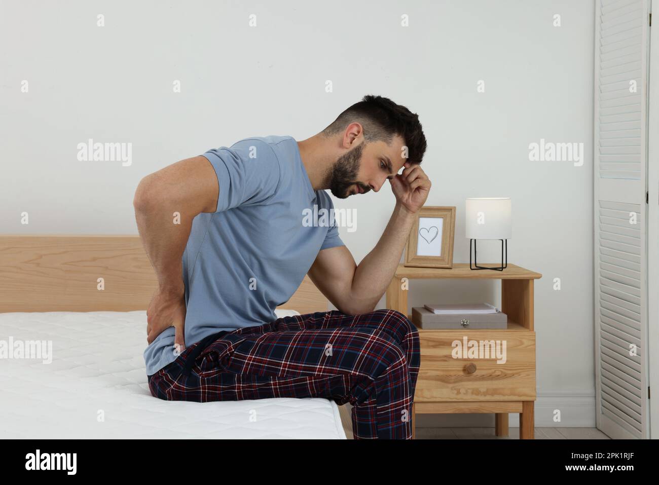 Man suffering from back pain after sleeping on mattress