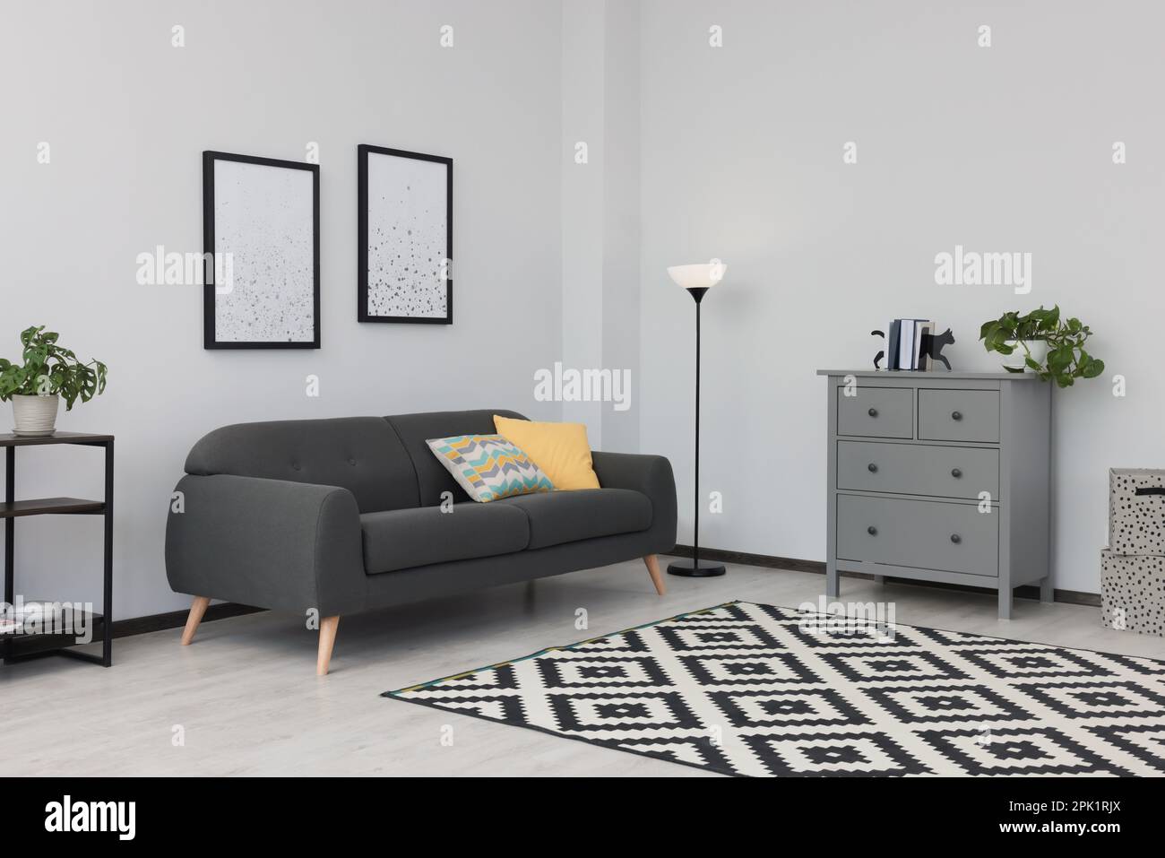 Beautiful living room interior with stylish grey sofa Stock Photo - Alamy