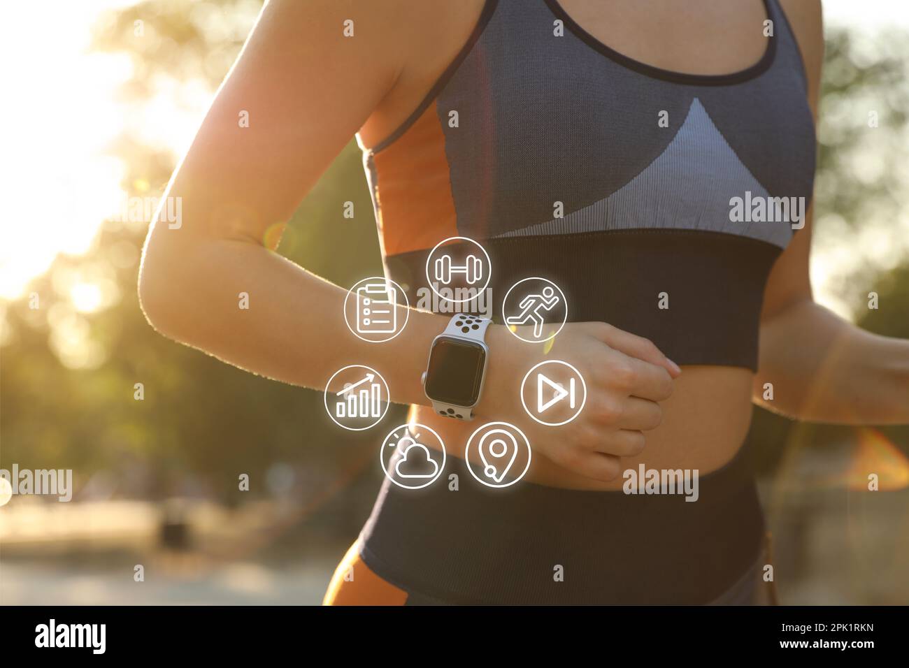 Woman wearing fitness tracker during training outdoors, closeup Stock Photo