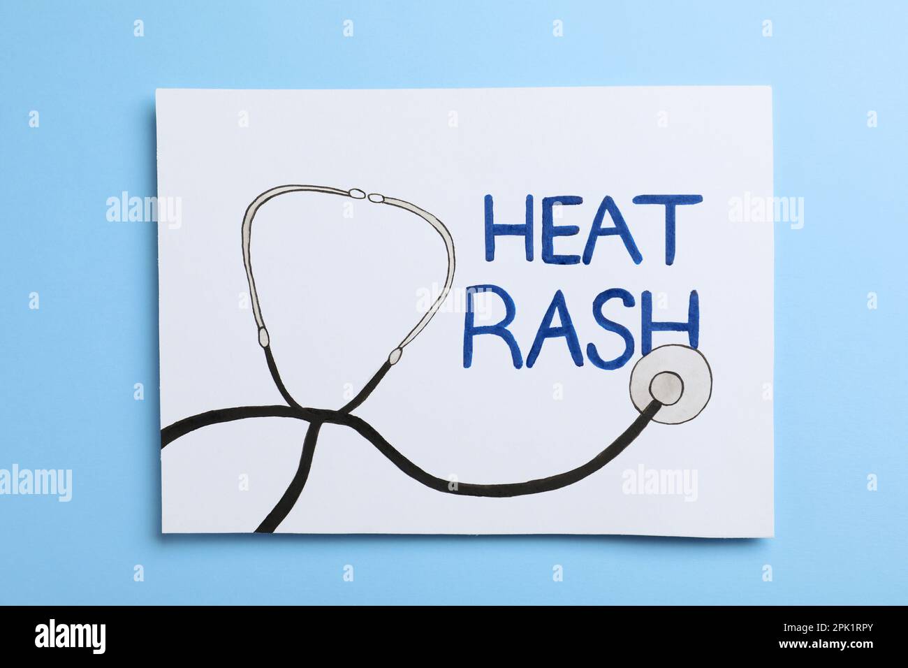 Sheet of paper with words Heat Rash and drawn stethoscope on light blue ...