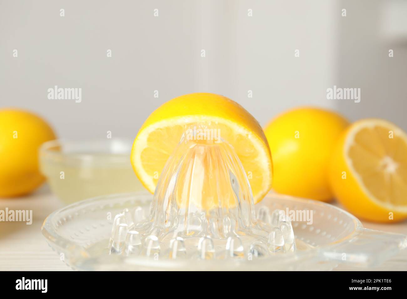 Plastic juicer with half of lemon on table, closeup Stock Photo